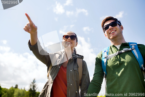 Image of happy couple with backpacks hiking outdoors