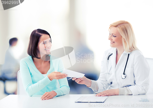 Image of doctor giving prescription to patient in hospital