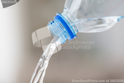 Image of close up of water pouring from plastic bottle