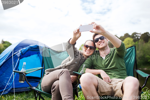 Image of couple of travelers taking selfie by smartphone