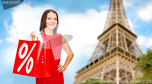 Image of woman with shopping bags over paris eiffel tower