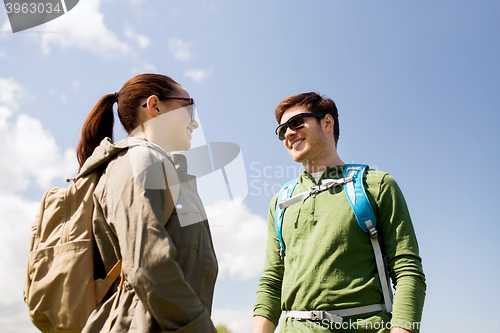 Image of happy couple with backpacks hiking outdoors