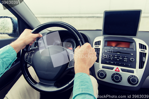 Image of close up of young man with tablet pc driving car