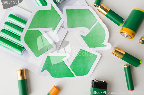 Image of close up of batteries and green recycling symbol