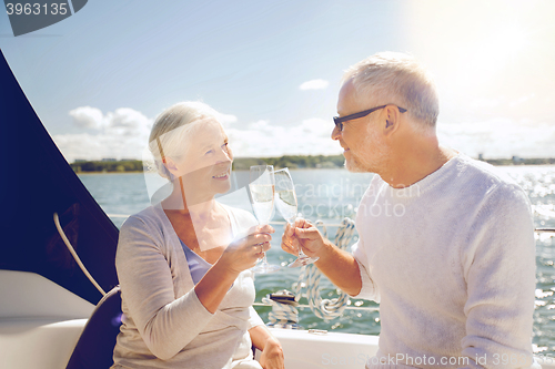 Image of senior couple clinking glasses on boat or yacht