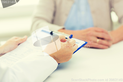 Image of close up of senior woman and doctor with clipboard