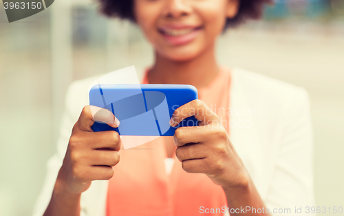 Image of close up of african woman with smartphone in city