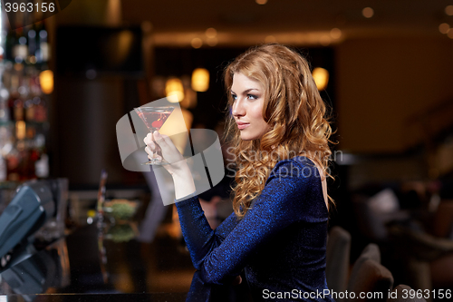 Image of glamorous woman with cocktail at night club or bar