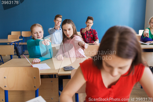 Image of students gossiping behind classmate back at school