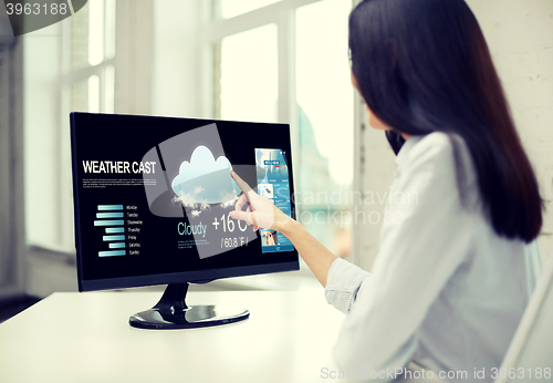 Image of close up of woman with weather cast on computer