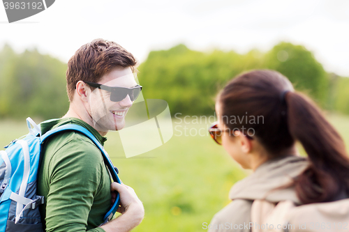 Image of smiling couple with backpacks in nature