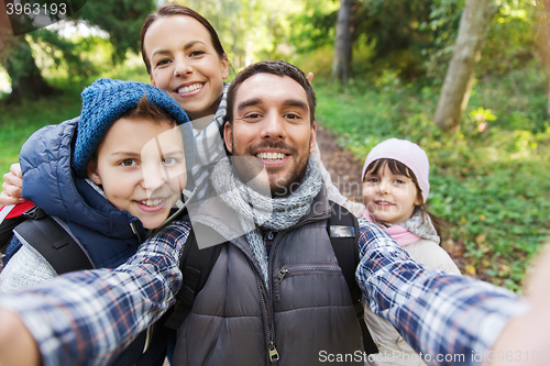 Image of family with backpacks taking selfie and hiking