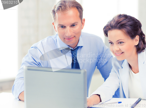 Image of man and woman working with laptop in office