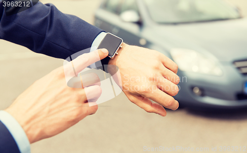 Image of close up of male hands with wristwatch and car