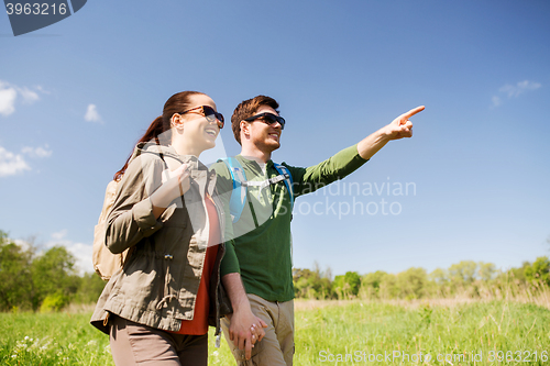 Image of happy couple with backpacks hiking outdoors