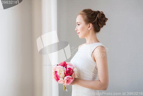 Image of bride or woman in white dress with flower bunch