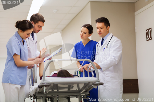 Image of medics with woman on hospital gurney at emergency