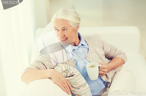 Image of happy senior woman with cup of tea at home