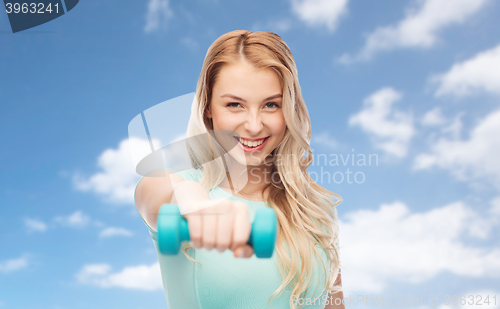 Image of smiling beautiful young sporty woman with dumbbell