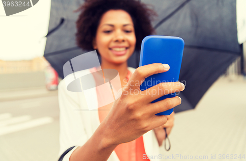 Image of close up of woman with umbrella and smartphone