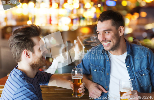 Image of happy male friends drinking beer at bar or pub