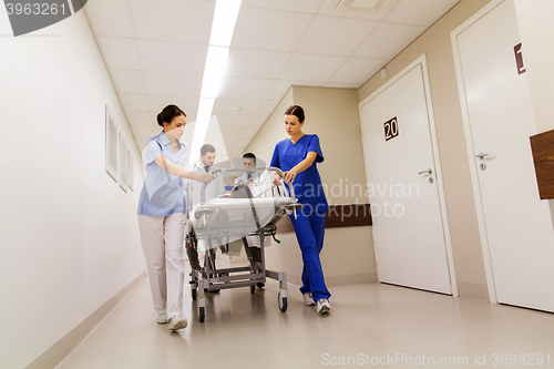 Image of medics with woman on hospital gurney at emergency