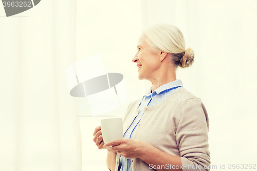 Image of happy senior woman with cup of tea or coffee