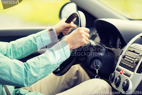 Image of close up of young man driving car