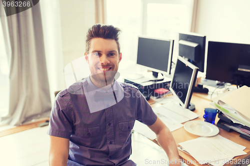 Image of happy creative male office worker with computers