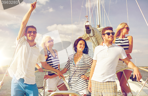 Image of smiling friends sailing on yacht