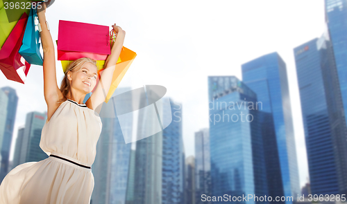 Image of happy woman with shopping bags over singapore city