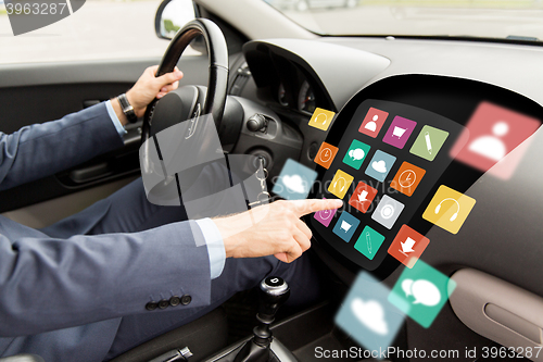 Image of man driving car with menu icons on board computer