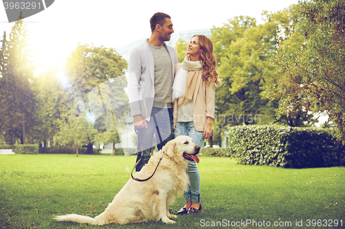 Image of happy couple with labrador dog walking in city