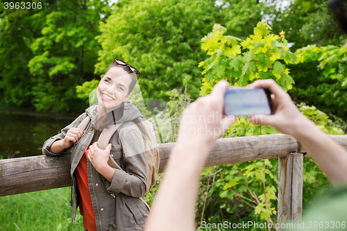 Image of couple with backpacks taking picture by smartphone