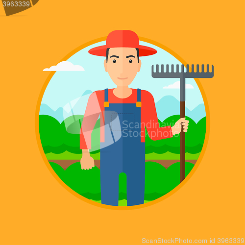 Image of Farmer with rake at cabbage field.