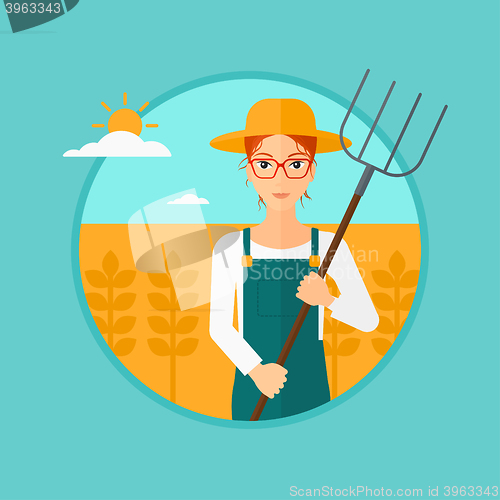 Image of Farmer with pitchfork in wheat field.