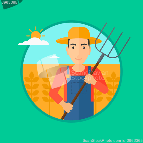 Image of Farmer with pitchfork in wheat field.