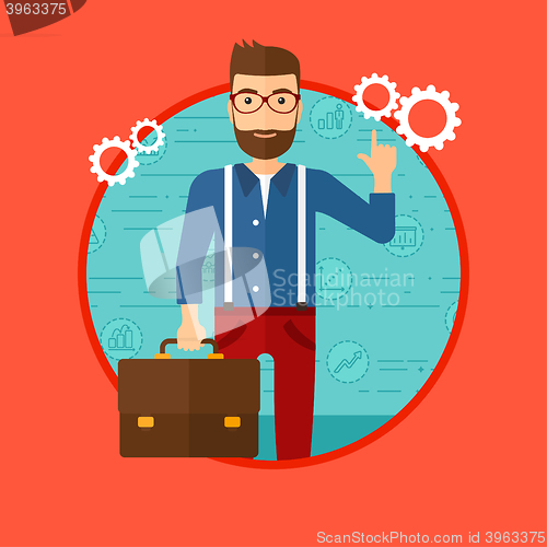 Image of Businessman pointing at cogwheels.