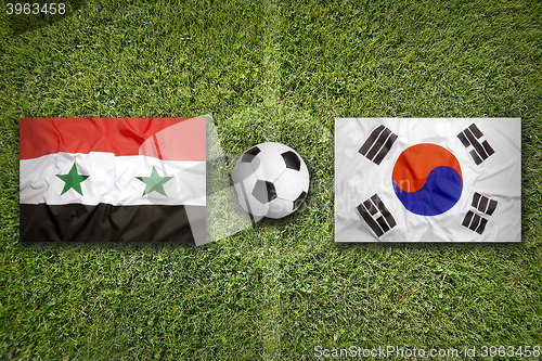 Image of Syria vs. South Korea flags on soccer field