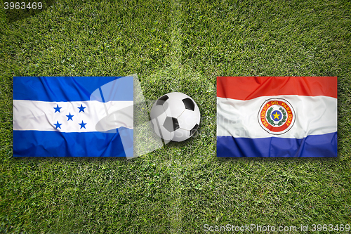 Image of Honduras vs. Paraguay flags on soccer field