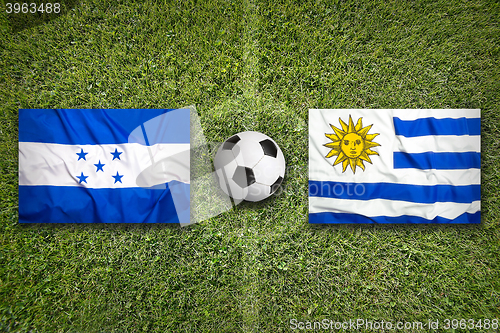 Image of Honduras vs. Uruguay flags on soccer field