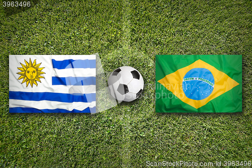 Image of Uruguay vs. Brazil flags on soccer field