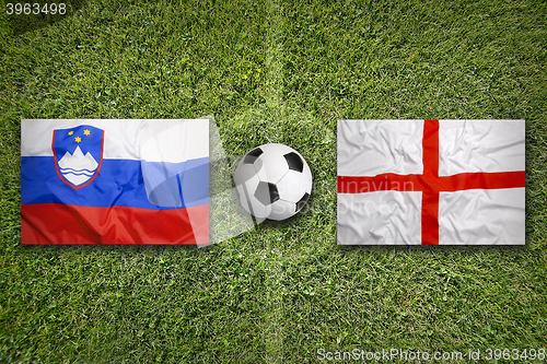 Image of Slovenia vs. England flags on soccer field