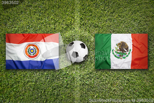 Image of Paraguay vs. Mexico flags on soccer field