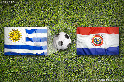 Image of Uruguay vs. Paraguay flags on soccer field