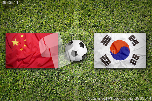 Image of China vs. South Korea flags on soccer field