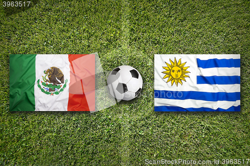 Image of Mexico vs. Uruguay flags on soccer field