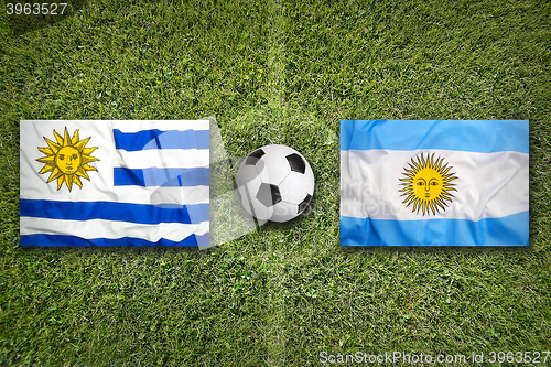 Image of Uruguay vs. Mexico flags on soccer field