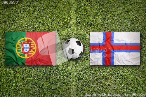 Image of Portugal vs. Faeroe Islands flags on soccer field
