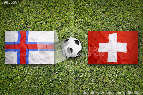 Image of Faeroe Islands vs. Switzerland flags on soccer field